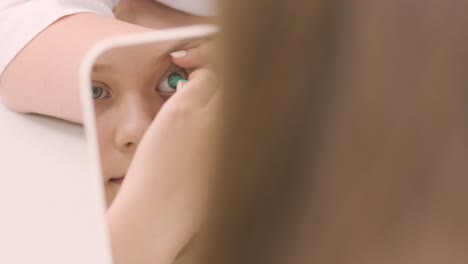 joven coloca la lente de contacto en la parte delantera del espejo con el médico. inserción de lente de contacto. lentes de contacto nocturnas