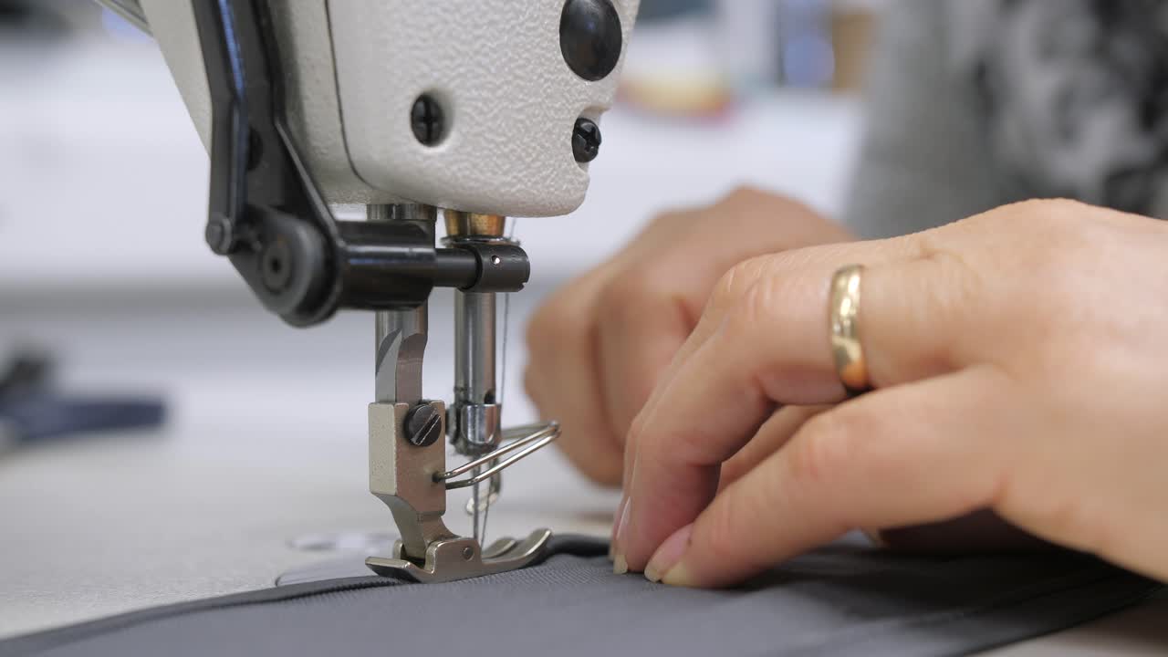 mujer caucásica cosiendo mascarilla protectora en la máquina, detalle de primer plano tiro estático