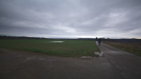 modern black swordsman warrior awaiting battle opponent in open field under grey sky, europe, 4k | muscular, intimidating, shadow, figure, blurry, dark clothes, powerful, blurry, walk, stop, search