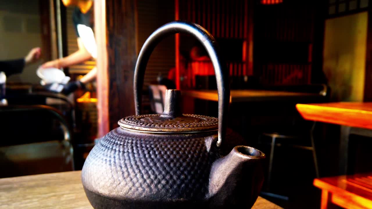 tetera de hierro fundido negro de patrón antiguo juego de té tetsubin japonés para estufa de leña con infusor de acero inoxidable para té suelto de hojas té floreciente 600ml 20oz fondo bokeh giratorio hecho a mano