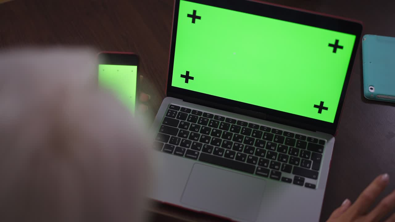 chromakey portátil y teléfono inteligente con reconocible mujer de negocios de cabello gris tocando los dedos en la mesa. exitosa mujer caucásica segura de sí misma planeando estrategia analizando negocios electrónicos. cámara lenta