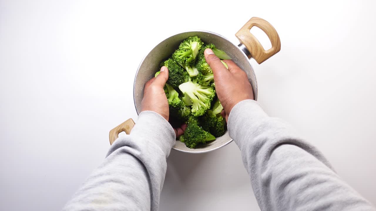 A person preparing broccoli for cooking