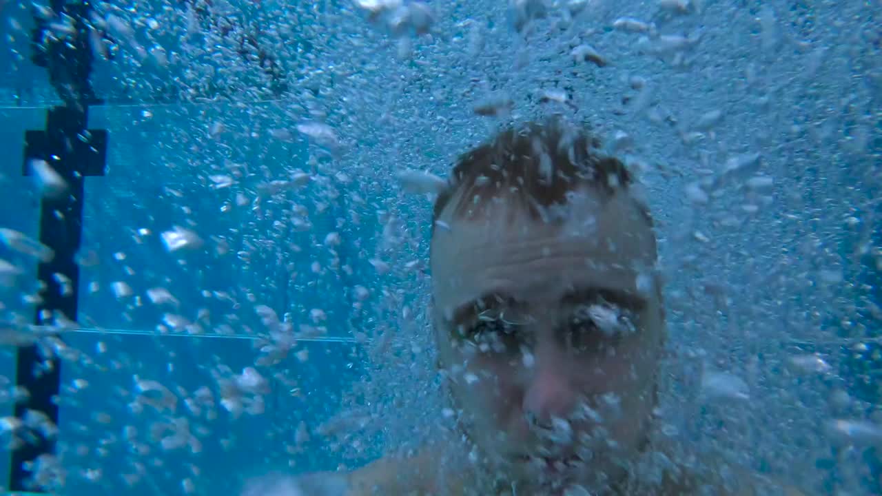 청년은 실내 수영장에 뛰어들기 전에 심호흡을 한다