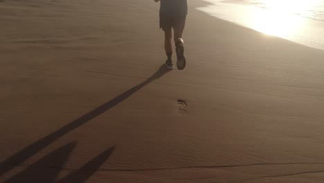 slow motion follow shot of kids' legs jogging on beach 4k