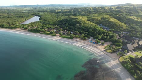 expansive view of natadola beach on viti levu, fiji with white sand, lush forest, and calm turquoise waters