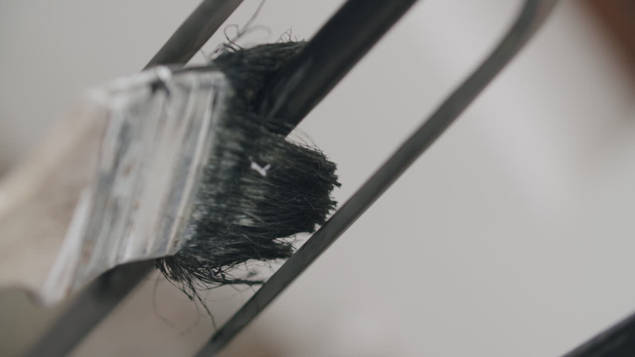 새로운 검은색 바니쉬로 오래된 울타리를 칠하는 pov