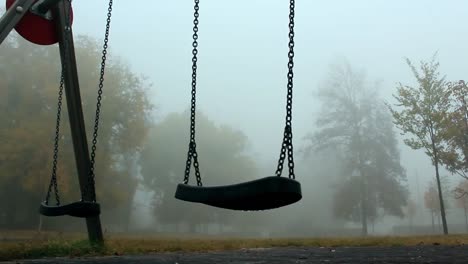 Empty-playground-with-swings-surrounded-with-fog,-abandoned-concept