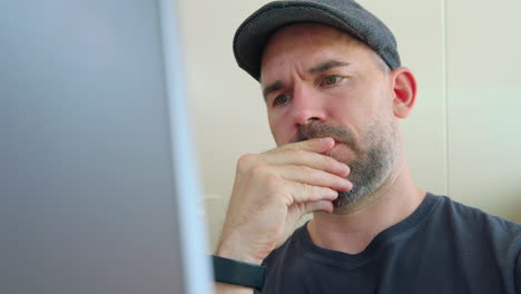 serious focused man looking at screen of his laptop - close up