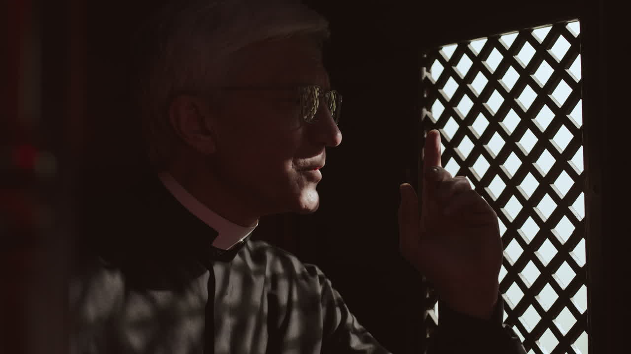 Senior Pastor Sitting in Confessional and Listening Confession
