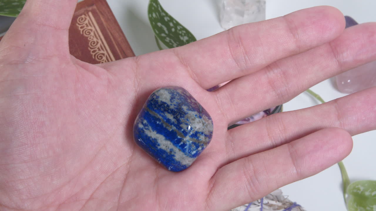 Pedra rolada de Lápis-lazúli na palma da mão.