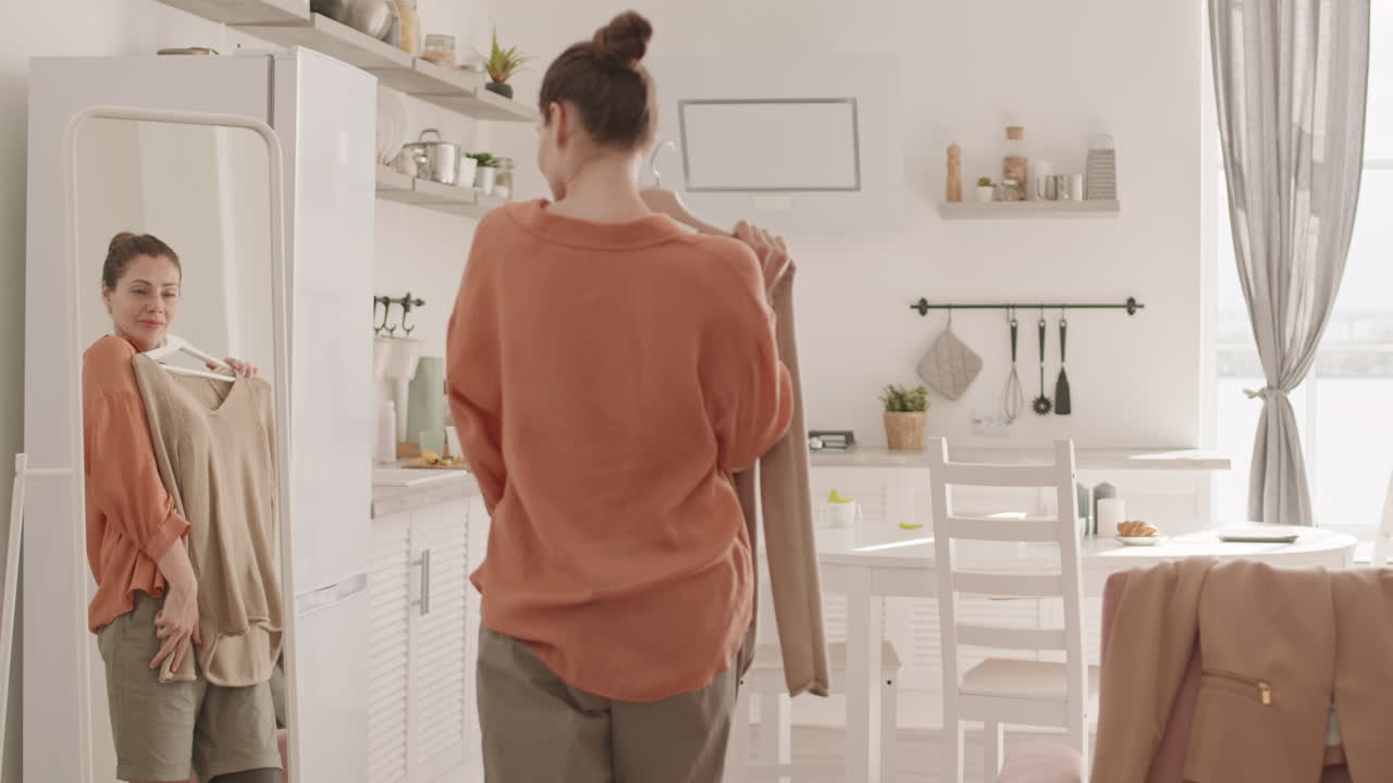 Woman Choosing Clothes while Looking in Mirror