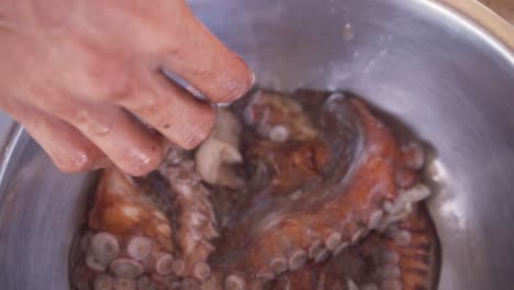 mano sosteniendo un pulpo grasiento comprado