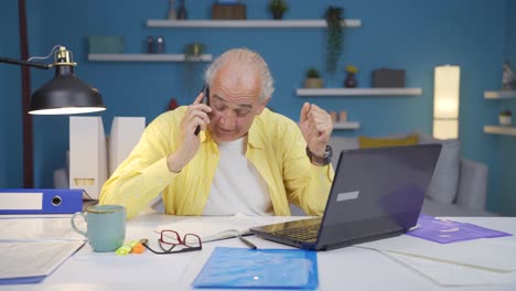 home office worker old man getting good news on the phone.