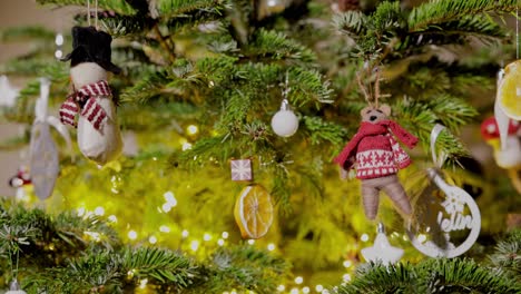 the ornaments and lights suspended from the christmas tree - close up