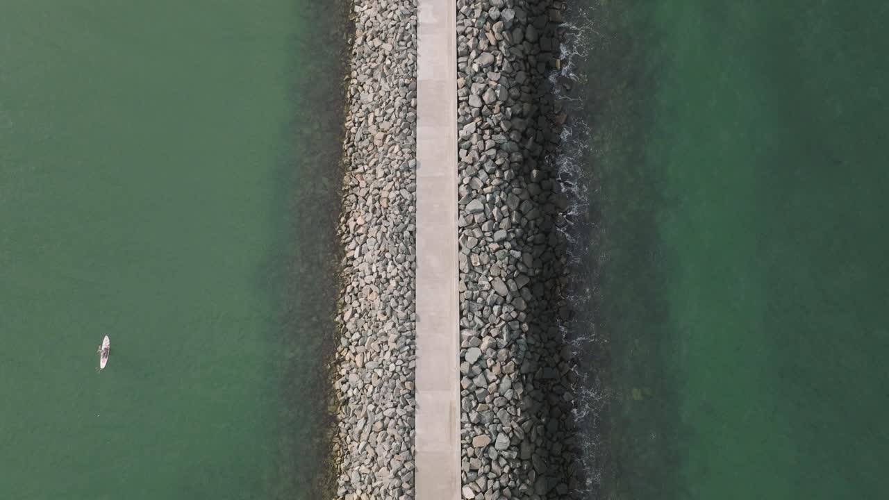 루마니아 콘스탄타 의 해변 에 있는 방파수 근처 에서 스탠드업 패들 보딩