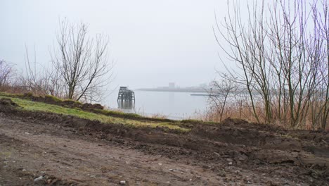 foggy misty cloudy day river schelde big cargo ship passing by in the distance