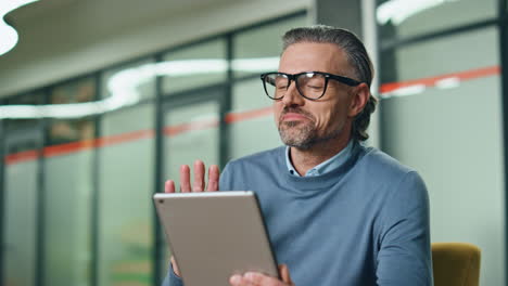 feliz ejecutivo de video chat tableta en el lugar de trabajo de primer plano. hombre gestando manos