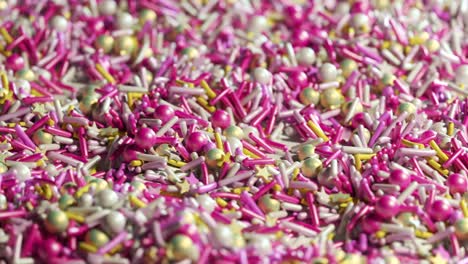 Closeup-animation-of-countless-colorful-sugar-sprinkles-stacked-in-an-endless-loop.-Soft-light-illuminates-candy-details.-Delicious-and-beautiful-cake-dessert-decoration.-Perfect-treat-for-kids.