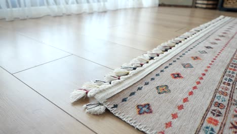 pequeño perro blanco jugando en una alfombra en una sala de estar