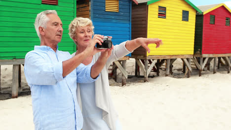 una pareja de mayores haciendo clic en la foto de la cámara en la playa