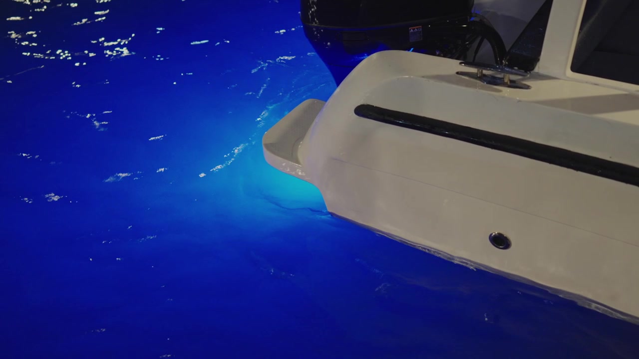 Ponte di poppa di motoscafo con luci LED subacquee blu di notte alle Maldive.