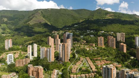 beautiful aerial view of luxury apartment buildings in medellin, colombia built into andes mountains on clear day