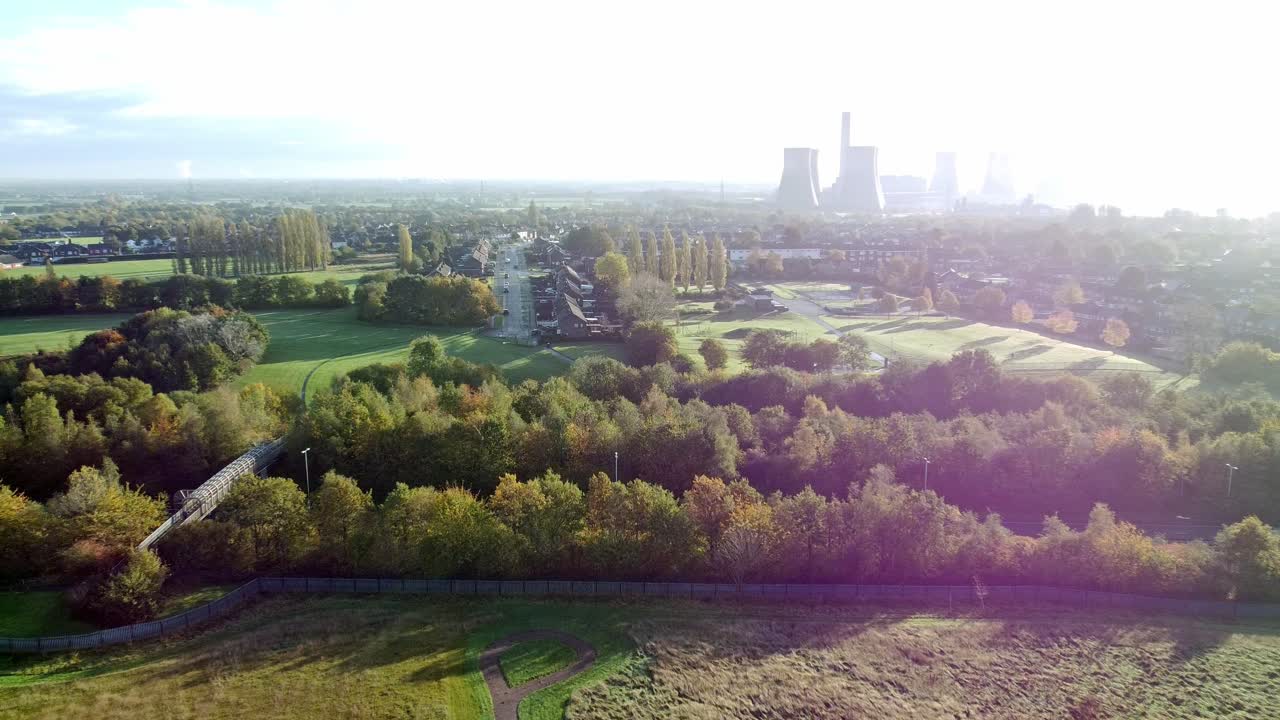 Aerial view zoom in to countryside town country road in lush foliage near power station rural scene