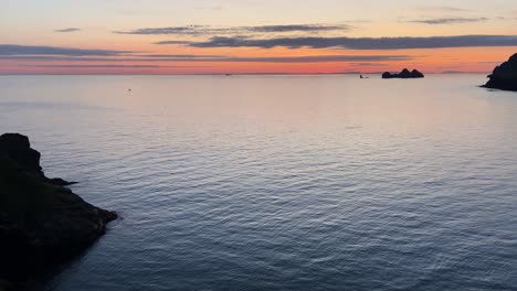 Horizonte-Del-Atardecer-Del-Mirador-De-Frailecillos,-Heimaey,-Islandia-Con-Pájaros-Volando-A-Través-De-La-Tranquila-Costa-Del-Océano-Marino