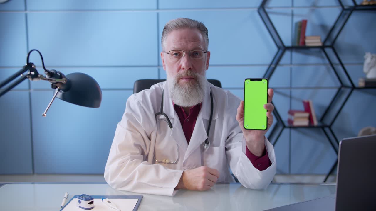 Professional Doctor holding vertical smartphone with copy space available in clinic cabinet. Healthcare specialist in hospital cabinet using smartphone with mockup