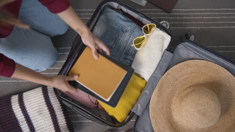 woman getting ready for travel, packing clothes and accessories in suitcase. concept of traveling, adventure.