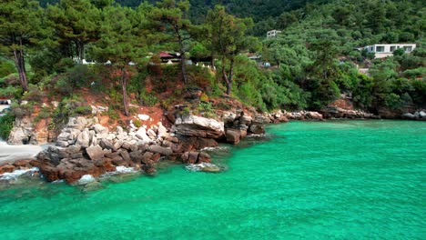 drone view of a seaside cliff with small isolated beaches, crystal clear water and green vegetation , thassos island, greece, europe