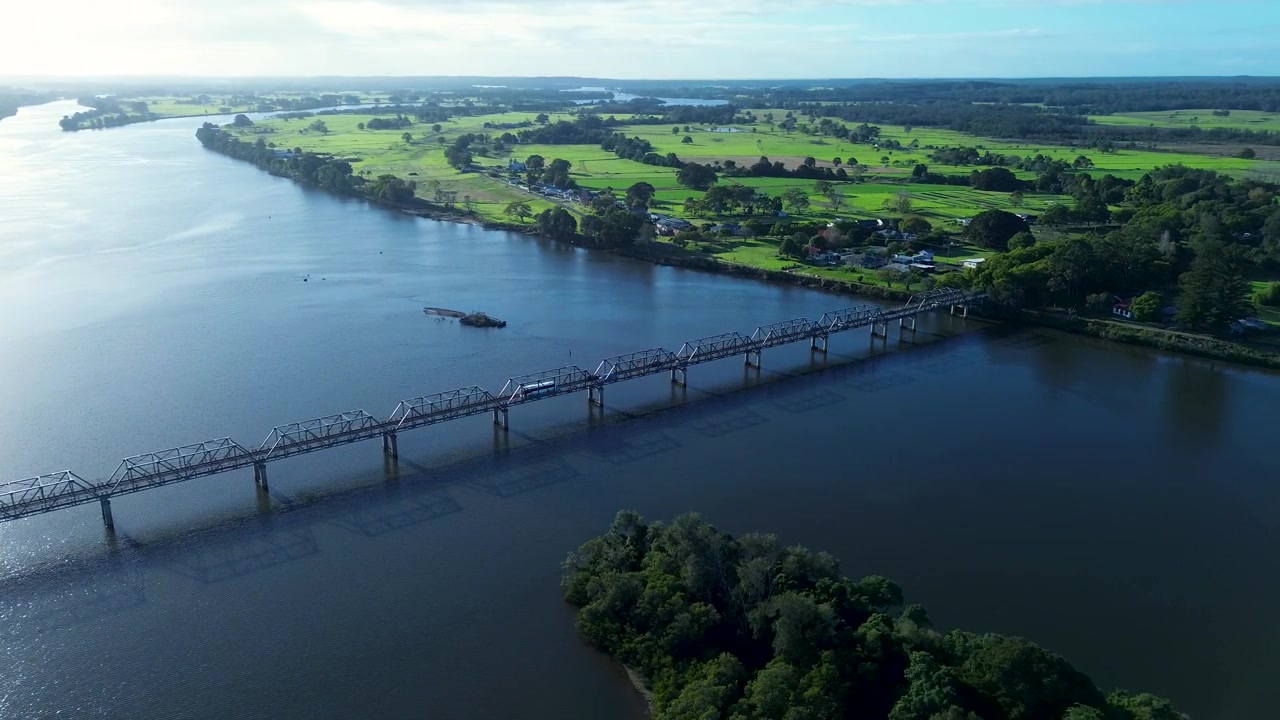 Paesaggio aereo con drone di mezzi di trasporto che viaggiano lungo il Ponte Martin con i corsi d'acqua del fiume Manning e il paesaggio rurale sullo sfondo nella città regionale di Taree, nella Mid North Coast del NSW, turismo in Australia