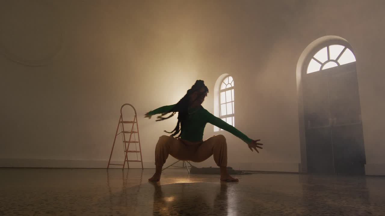 Ritratto di ballerina di etnia mista che balla in uno studio di danza, movimento rallentato