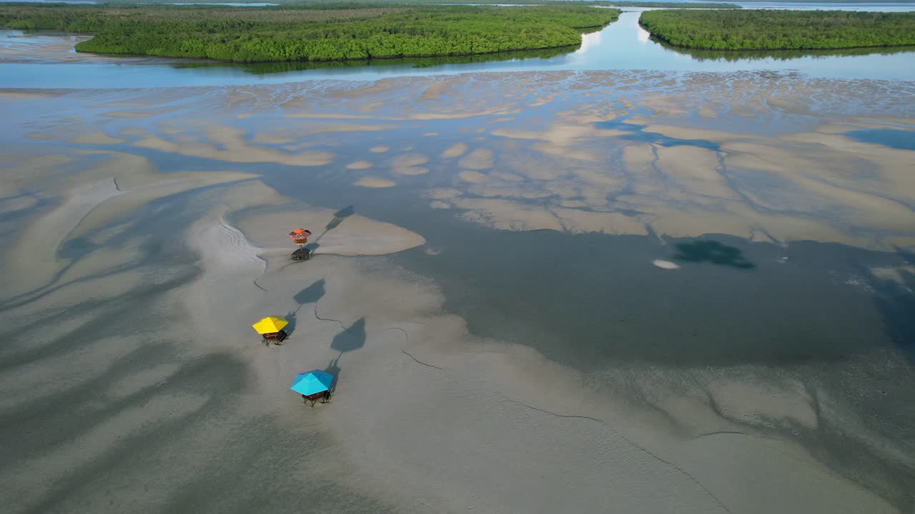 리봉의 열대 모래톱에 있는 다채로운 정자 우산