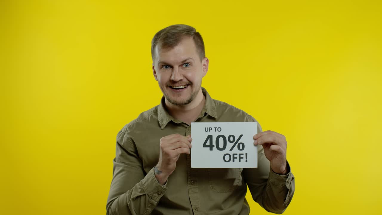 hombre atractivo mostrando hasta un 40 por ciento de descuento inscripciones señales, regocijándose buenos descuentos, precios bajos