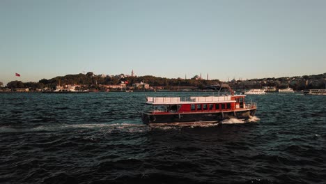 Vista-Estática-De-Los-Transbordadores-Que-Cruzan-El-Río-En-El-Bósforo,-Turquía-Por-La-Noche-Con-La-Vista-De-La-Ciudad-Al-Fondo