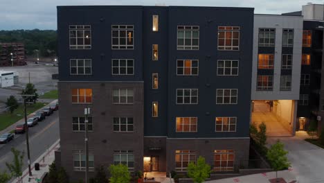 Descending-aerial-establishing-shot-of-residential-apartment-building-at-night