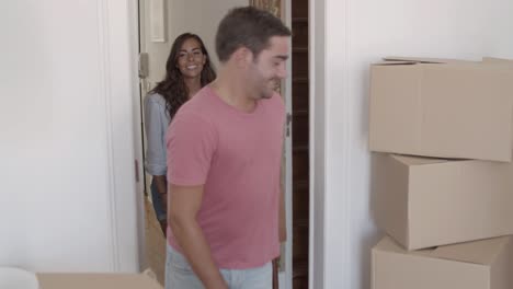 happy couple carrying small table into living room together