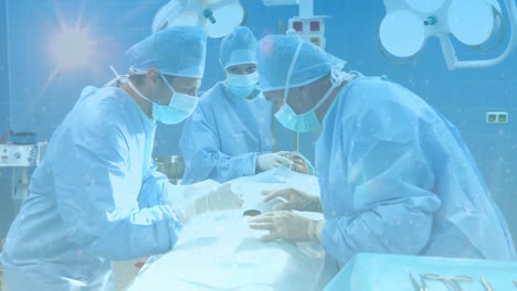 Digital-composition-of-spots-of-light-against-team-of-surgeons-performing-surgery-at-hospital