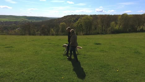 aerial shot of mature couple and dog on walk in countryside