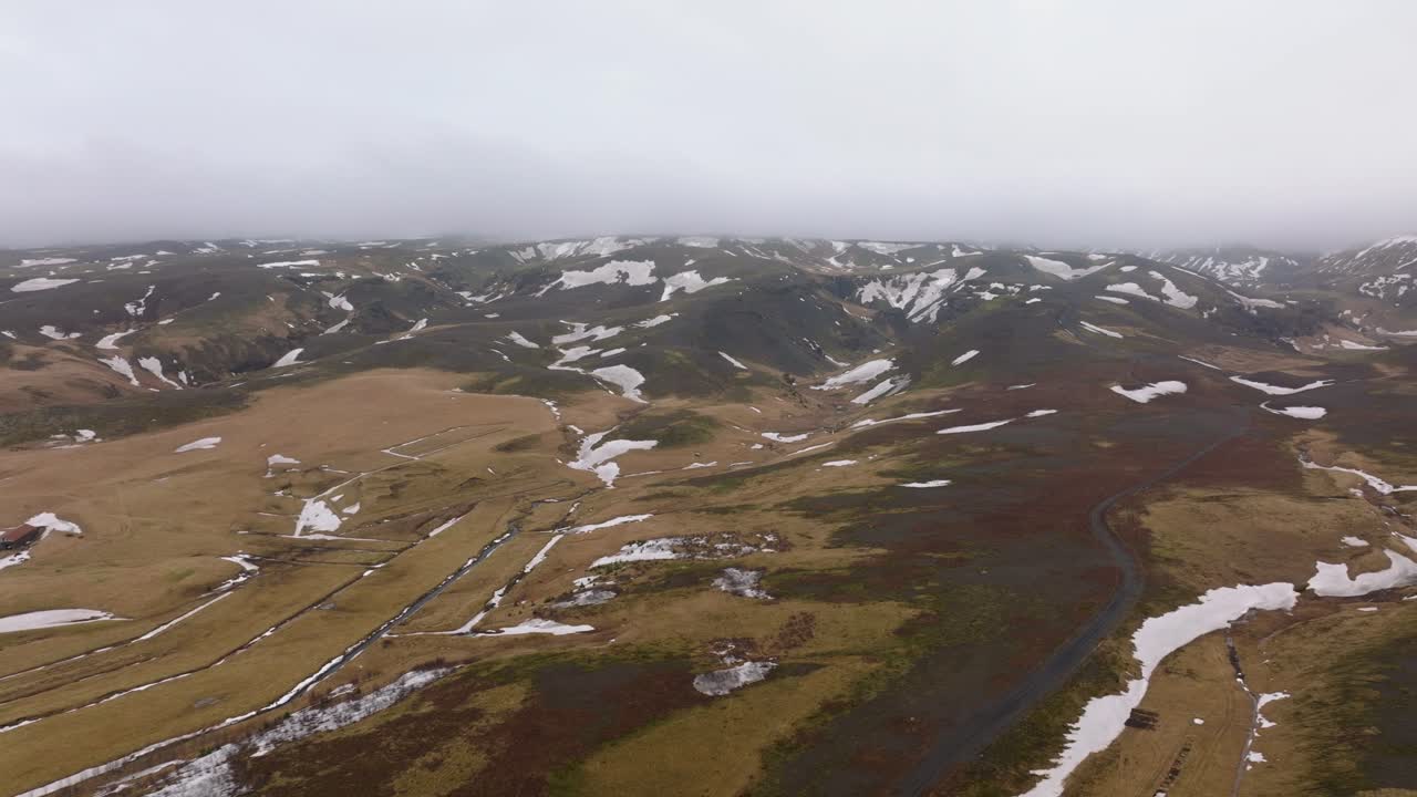 vista panorámica aérea de las montañas con nieve derretida, en un día nublado y nublado, islandia