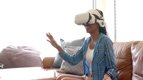 african american young woman wearing virtual reality headset, reaching out