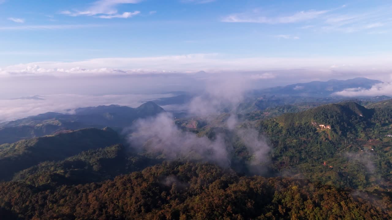 Cinematic 4K drone footage flying high above a "sea of clouds" and fog-filled valleys in the Philippines mountains. The morning sunrise illuminates the jungle peaks