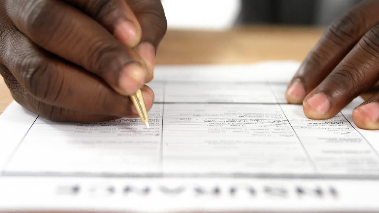 Mid-section of businessman filling a insurance form