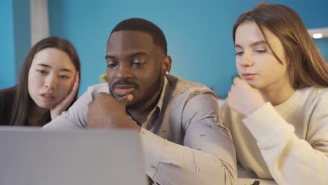 asian, african and european college friends working on laptop.