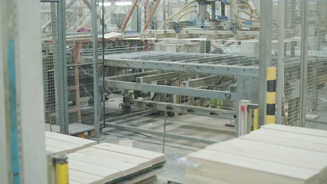 Braccio robotico automatizzato che impila tavole di legno in una fabbrica moderna.