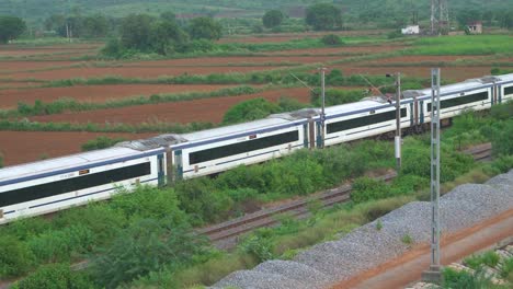 pan close shot of vande bharat express train moving fast on a railway track of gwalior india