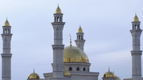 a muslim islamic mosque with golden minarets and a crescent moon against the sky.a religious temple for praying and worshipping the god of muslims in islamic culture and belief in allah.video 4k zoom