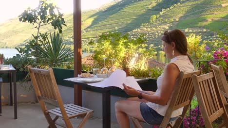 young woman looking at the menu, overseeing the douro valley famous for its wine