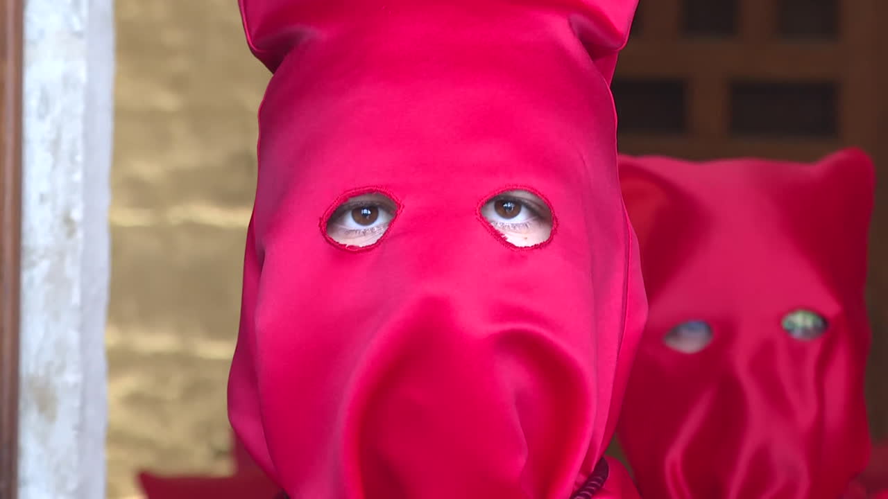 People in red masks during a religious procession
